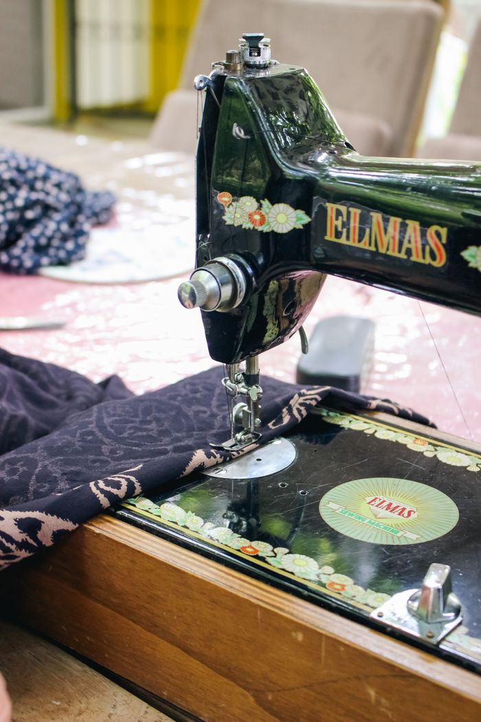 services-01 Close-up of a vintage sewing machine with fabric in a tailor's workshop.