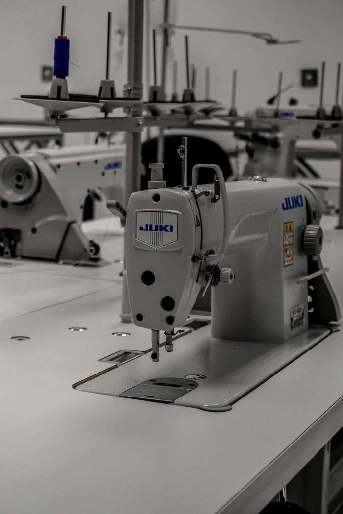 Close-up of an industrial sewing machine in a well-equipped textile workshop.