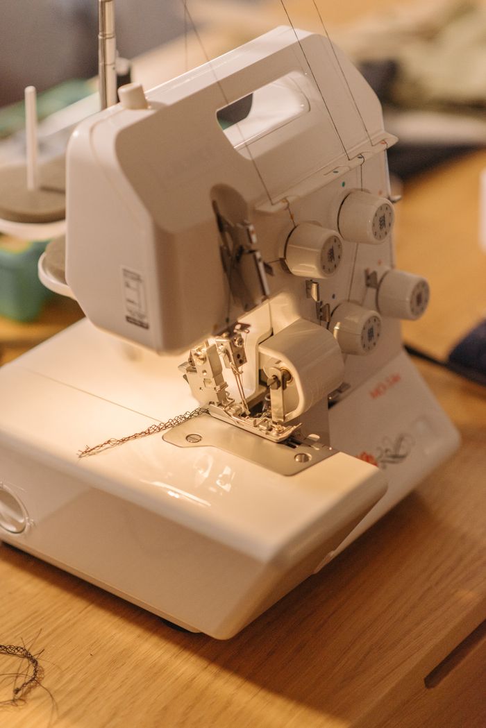 services-01 Detailed view of an active sewing machine with thread and fabric, ideal for tailoring content.